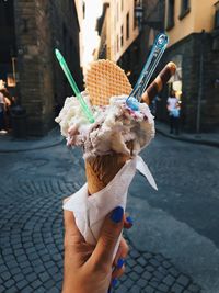 Woman holding ice cream cone on street