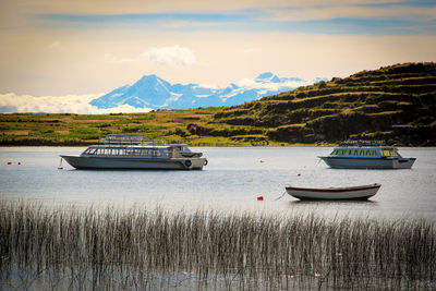 Boats moored in lake against sky
