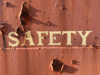 Close-up of safety text on rusty wall