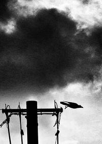 Low angle view of barbed wire against cloudy sky