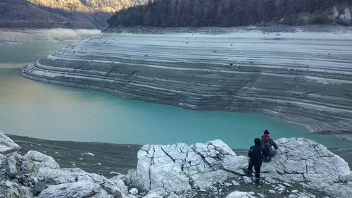 Rear view of people by lake