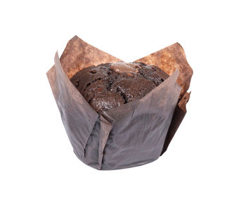 Close-up of chocolate cake on rock against white background