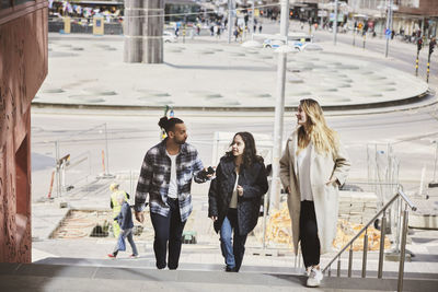 Friends walking up stairs in city