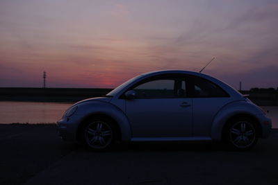 Car on road against sky at sunset