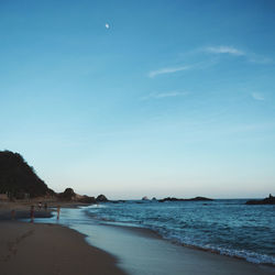 Scenic view of beach against clear blue sky