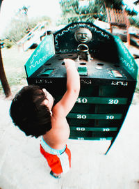 Rear view of a boy holding camera