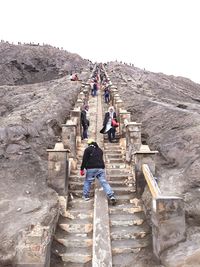 Rear view of people walking on staircase