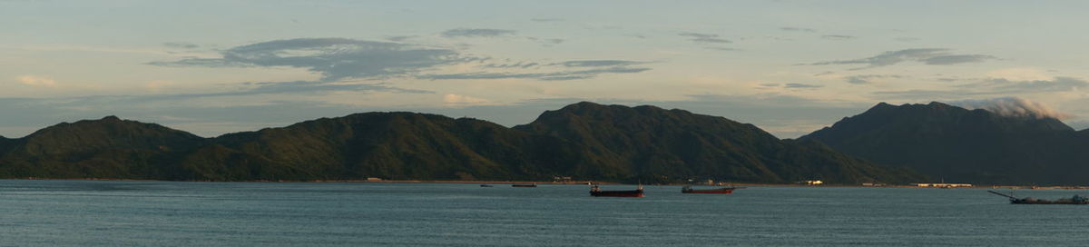 Scenic view of sea and mountains against sky during sunset