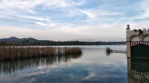 Scenic view of lake by building against sky