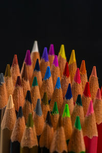 Close-up of multi colored pencils against black background