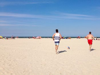 People playing football on the beach