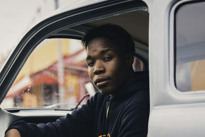 Portrait of young man sitting in car