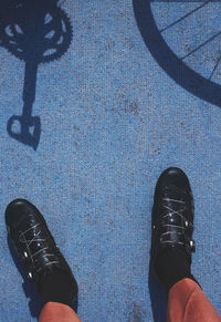 Low section of man standing against blue wall