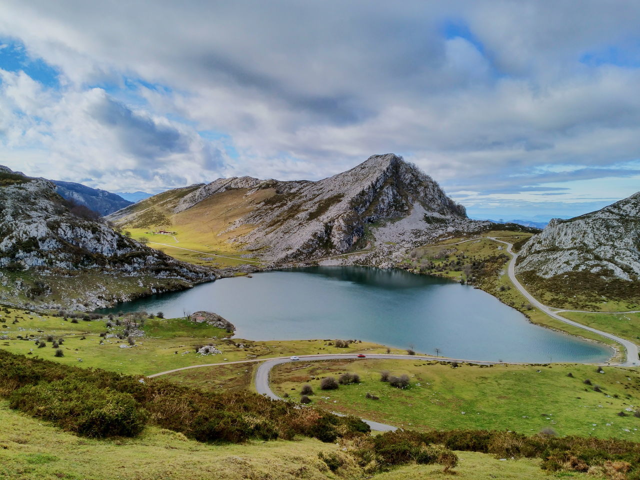 mountain, sky, tranquil scene, tranquility, scenics, cloud - sky, beauty in nature, landscape, nature, mountain range, cloudy, water, cloud, lake, grass, non-urban scene, idyllic, day, remote, green color