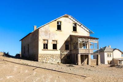 Low angle view of old building against clear blue sky