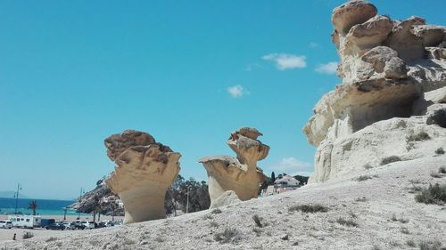 Low angle view of rock formations against blue sky