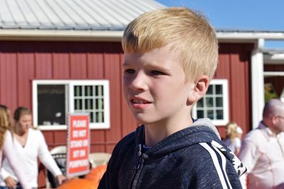 Close-up of boy against house 