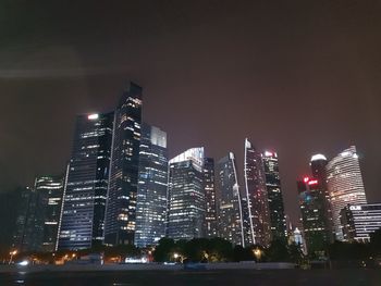 Low angle view of illuminated buildings against sky at night