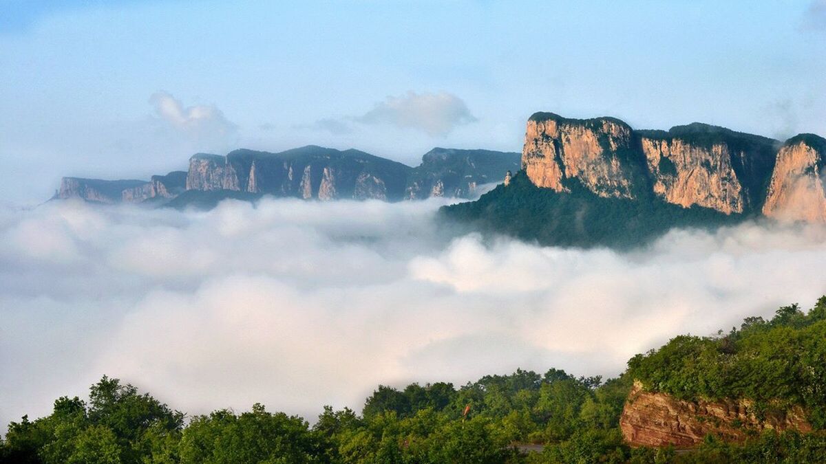 mountain, sky, scenics, tree, beauty in nature, cloud - sky, nature, tranquil scene, rock formation, tranquility, rock - object, building exterior, architecture, landscape, physical geography, built structure, idyllic, mountain range, cliff, day