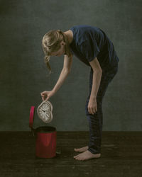 A kid throwing the watch to the trash can