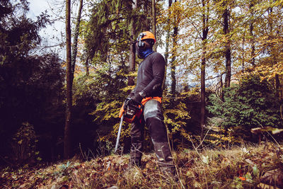 Woodcutter man in the forest woodcutter equipment and tools hard work outdoor