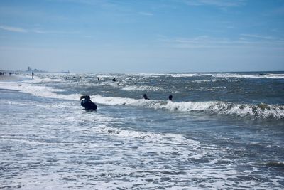 People enjoying in sea against sky