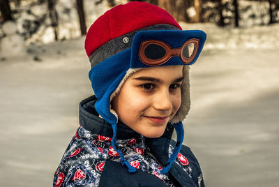 Close-up of smiling boy standing outdoors during winter