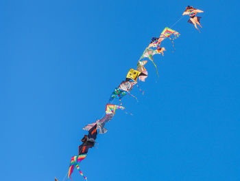 Low angle view of decoration hanging against clear blue sky