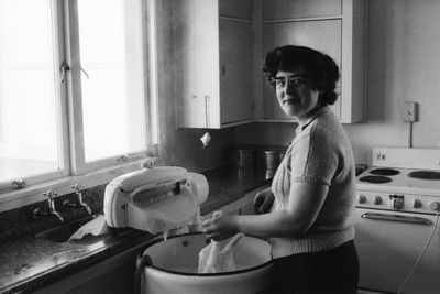 Side view of senior woman standing at home