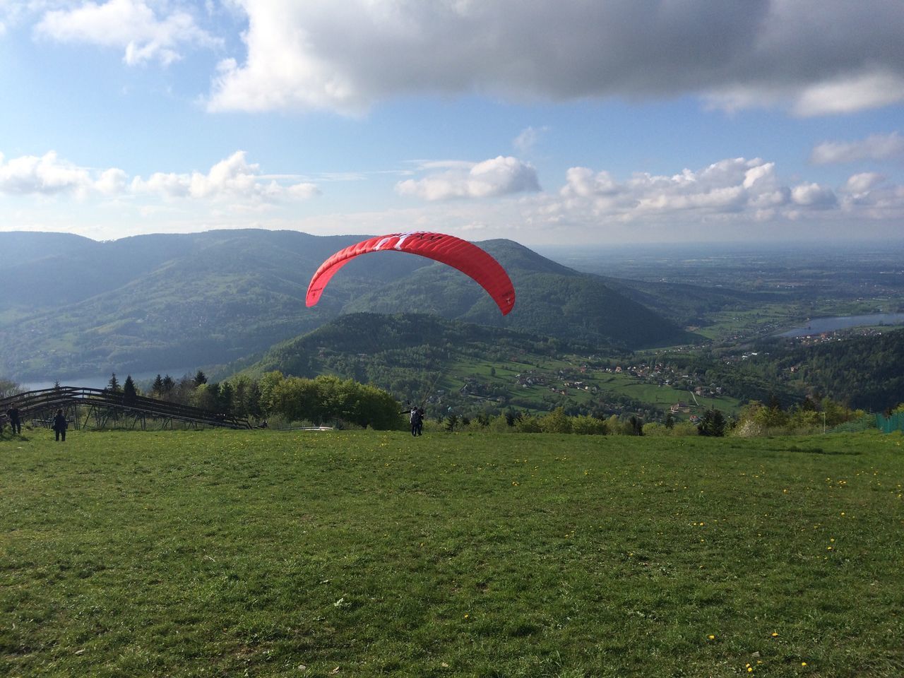 sky, mountain, landscape, flying, cloud - sky, mid-air, parachute, tree, grass, sport, field, cloud, flag, nature, freedom, mountain range, leisure activity, scenics, adventure