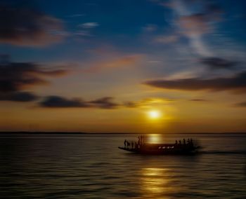 Silhouette boat in sea against sky during sunset