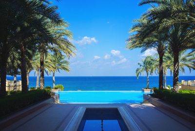 Swimming pool in resort by sea against sky