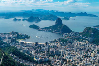 High angle view of city by sea against sky