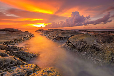 Scenic view of dramatic sky over sea during sunset