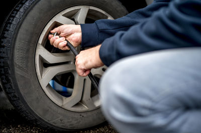 Hand's of man filling air in tire at gas station
