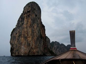 Rock formations by sea against sky