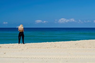 Rear view of woman standing on beach