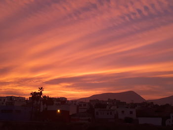 High angle view of townscape against orange sky