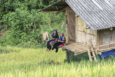 People sitting outside house