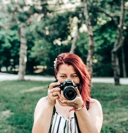 Portrait of woman photographing with camera