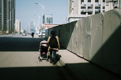 Mother pushing baby in stroller on street