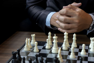 Midsection of person playing chess at home