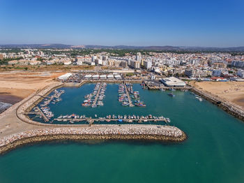 High angle view of illuminated buildings by sea against sky