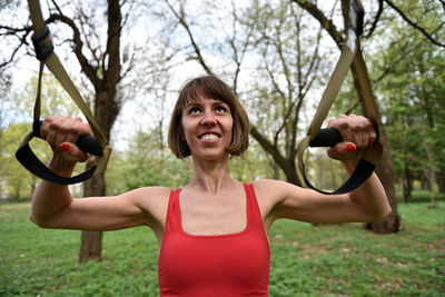 Confident mid adult woman exercising at park