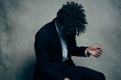 Man looking at camera while standing against wall