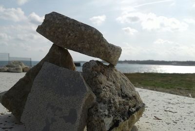 Close-up of rock on beach against sky