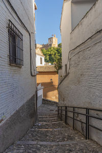 Footpath amidst buildings against sky