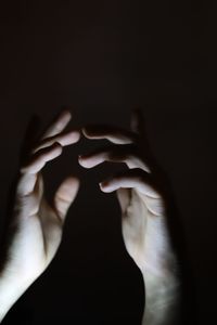 Close-up of woman hand against black background