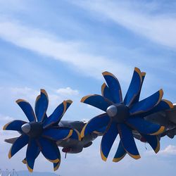 Low angle view of flowers against blue sky