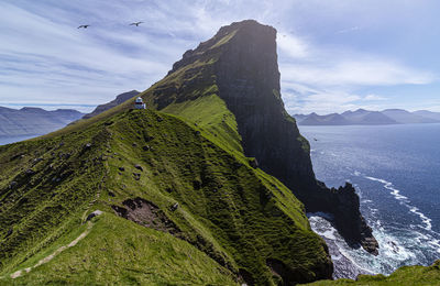 Scenic view of sea and mountains against sky